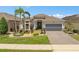 Charming single-story home featuring a well-manicured lawn and a two-car garage at 2554 Stargrass Cir, Clermont, FL 34715