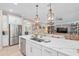 Kitchen island with a stainless steel sink and gooseneck faucet and an open view of the living room at 2554 Stargrass Cir, Clermont, FL 34715