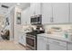 Modern kitchen with stainless steel appliances, white cabinets, and ample counter space with an open layout at 2554 Stargrass Cir, Clermont, FL 34715