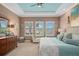 Bright main bedroom boasts multiple windows, neutral walls, and a decorative tray ceiling with a ceiling fan at 2554 Stargrass Cir, Clermont, FL 34715