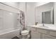 Bright bathroom with shower-tub combo, a grey accent rug and large mirror above the vanity at 266 Marcello Blvd, Kissimmee, FL 34746
