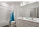 Bright bathroom featuring double sinks, a shower-tub combo with blue curtains, and a large mirror at 266 Marcello Blvd, Kissimmee, FL 34746