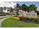 Inviting Bella Vida community entrance featuring a decorative fountain, lush landscaping, and mature palm trees at 266 Marcello Blvd, Kissimmee, FL 34746
