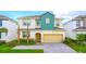 Charming two-story home featuring a well-manicured lawn, two palm trees, and a welcoming entrance at 266 Marcello Blvd, Kissimmee, FL 34746