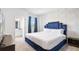 Elegant main bedroom with a luxurious blue upholstered headboard, ensuite bathroom, and neutral decor for a serene retreat at 266 Marcello Blvd, Kissimmee, FL 34746
