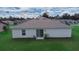 A home's back exterior featuring a sliding glass door and lush, green lawn at 2701 Sw 153Rd Ln, Ocala, FL 34473