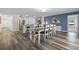 Open-concept dining area featuring stylish wood flooring, a modern table set, and adjacent kitchen at 2701 Sw 153Rd Ln, Ocala, FL 34473