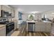 Modern kitchen with stainless steel appliances, a convenient island, and an open view to the dining and living areas at 2701 Sw 153Rd Ln, Ocala, FL 34473