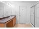 Bright bathroom features a walk-in shower and a vanity with wood cabinets and a large mirror at 305 Grande Lake Dr, Daytona Beach, FL 32124