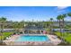 Community pool area with a covered pavilion, surrounded by palm trees, lounge chairs and fencing at 305 Grande Lake Dr, Daytona Beach, FL 32124