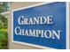 Grande Champion community sign, in white letters on a blue background with a white frame, set in a tan wall at 305 Grande Lake Dr, Daytona Beach, FL 32124