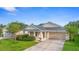 Charming single-story home featuring a covered porch, two car garage, and well-manicured landscaping at 305 Grande Lake Dr, Daytona Beach, FL 32124