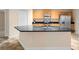 Kitchen island featuring black granite countertops, sink, and ample cabinet space at 305 Grande Lake Dr, Daytona Beach, FL 32124