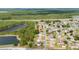 An aerial view displays a well-maintained home near a pond, surrounded by lush trees and neat landscaping at 313 Greenwich Ct, Kissimmee, FL 34758