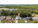 An aerial view of a home near a large pond and forested area, surrounded by other residences at 313 Greenwich Ct, Kissimmee, FL 34758