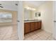 En-suite bathroom with a double sink vanity, large mirror, tile flooring, and a neutral color scheme at 313 Greenwich Ct, Kissimmee, FL 34758