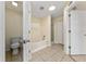 Well-lit bathroom featuring tile floors, a combination tub and shower, plus a separate toilet area at 313 Greenwich Ct, Kissimmee, FL 34758