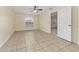 Bright bedroom featuring neutral walls, tile flooring, ceiling fan, and natural light from a window at 313 Greenwich Ct, Kissimmee, FL 34758