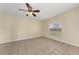 Simple bedroom with tile floors, a ceiling fan, a bright window, and neutral-colored walls at 313 Greenwich Ct, Kissimmee, FL 34758