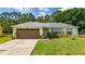Charming single-story home featuring a well-maintained lawn and an attached two-car garage at 313 Greenwich Ct, Kissimmee, FL 34758