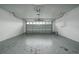 Spacious garage featuring a light grey floor with epoxy spots and a modern, partially open garage door at 313 Greenwich Ct, Kissimmee, FL 34758