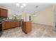 Bright kitchen with an island, tile backsplash, stainless steel dishwasher, and tile flooring leading to the dining area at 313 Greenwich Ct, Kissimmee, FL 34758