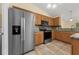 Open kitchen featuring stainless steel appliances, stone countertops, tiled floors, and bright lighting at 313 Greenwich Ct, Kissimmee, FL 34758