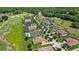 Aerial view of upscale neighborhood with tree-lined streets and well-maintained lawns near a lush golf course at 31754 Red Tail Blvd, Sorrento, FL 32776