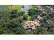 Aerial view of estate home with custom roof surrounded by dense trees, golf course, and ponds at 31754 Red Tail Blvd, Sorrento, FL 32776
