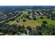 Aerial view showcases sprawling golf course community with lush landscaping, and serene pond at 31754 Red Tail Blvd, Sorrento, FL 32776