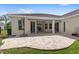 Paver patio with a covered area looks out to a meticulously maintained lawn at 31754 Red Tail Blvd, Sorrento, FL 32776