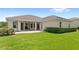 Manicured backyard with a paver patio, green lawn, and trimmed hedges provide a tranquil outdoor space at 31754 Red Tail Blvd, Sorrento, FL 32776