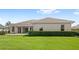 Expansive backyard features lush green grass and a neatly trimmed hedge along the property line at 31754 Red Tail Blvd, Sorrento, FL 32776