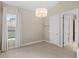 Bright bedroom with a chandelier, plush carpet, and a doorway leading to other areas of the home at 31754 Red Tail Blvd, Sorrento, FL 32776