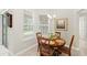 Cozy breakfast nook with a round wooden table, comfortable seating, and bright natural light from the surrounding windows at 31754 Red Tail Blvd, Sorrento, FL 32776