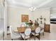 Elegant dining area features a stylish chandelier, decorative art, and comfortable seating for six at 31754 Red Tail Blvd, Sorrento, FL 32776