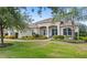 Charming, landscaped front yard featuring a lush lawn, colorful plants, and mature trees accentuating this inviting home at 31754 Red Tail Blvd, Sorrento, FL 32776