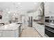 Open kitchen with stainless steel appliances, white cabinetry, granite island and adjacent dining area at 31754 Red Tail Blvd, Sorrento, FL 32776