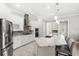 Modern, well-lit kitchen with white cabinets, granite countertops, stainless steel appliances, and an island with seating at 31754 Red Tail Blvd, Sorrento, FL 32776
