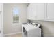 Efficient laundry room equipped with a washer, dryer, and ample overhead cabinet storage at 31754 Red Tail Blvd, Sorrento, FL 32776