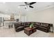 Open-concept living room featuring a large leather sectional sofa, and a stylish kitchen with stainless steel appliances at 31754 Red Tail Blvd, Sorrento, FL 32776
