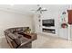 Bright living room boasts a modern fireplace with a large TV and decorative shelving, creating a cozy atmosphere at 31754 Red Tail Blvd, Sorrento, FL 32776