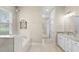 Elegant bathroom showcasing a soaking tub, glass-enclosed shower, and a view into the walk-in closet, providing a spa-like retreat at 31754 Red Tail Blvd, Sorrento, FL 32776