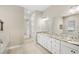 The main bathroom features double sinks, granite counters, a large mirror, and a tub with a shower at 31754 Red Tail Blvd, Sorrento, FL 32776
