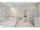 Well-lit bathroom with granite counters, modern fixtures, a glass-enclosed shower, and seamless access to the main bedroom at 31754 Red Tail Blvd, Sorrento, FL 32776