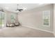 Inviting main bedroom featuring plush carpeting, elegant tray ceiling, and comfortable seating area with scenic outdoor views at 31754 Red Tail Blvd, Sorrento, FL 32776