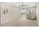 Spacious main bedroom with a tray ceiling, plush carpet, and sliding glass doors to the backyard, with comfortable seating at 31754 Red Tail Blvd, Sorrento, FL 32776