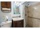 Well-lit bathroom featuring a shower with tiled walls, and a sink with decorative mirror at 3300 Needles Dr, Orlando, FL 32810