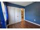 Comfortable bedroom featuring wood-look floors, closet, and an open door to another room at 3300 Needles Dr, Orlando, FL 32810