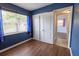 Cozy bedroom features wood-look floors, closet, and a window with blue curtains offering natural light at 3300 Needles Dr, Orlando, FL 32810